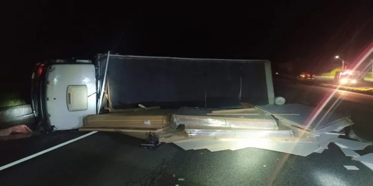 CAMINHÃO CARREGADO DE PLACAS DE MADEIRA TOMBA NA VIA DUTRA, EM PIRAÍ